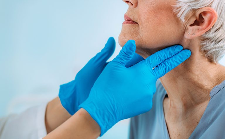 Controllo della ghiandola tiroidea. Medico di endocrinologia che esamina la donna anziana alla clinica.